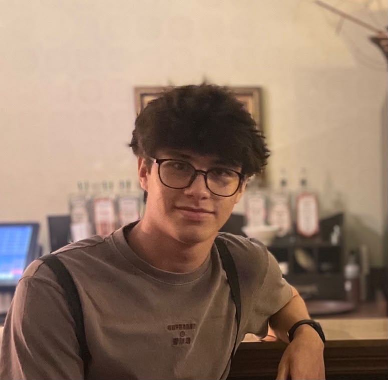Dennis Ng, the maker of the Newsboard, at a counter in warm light.